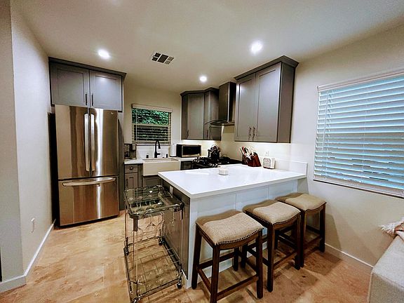 View of kitchen and peninsula with seating for 3.