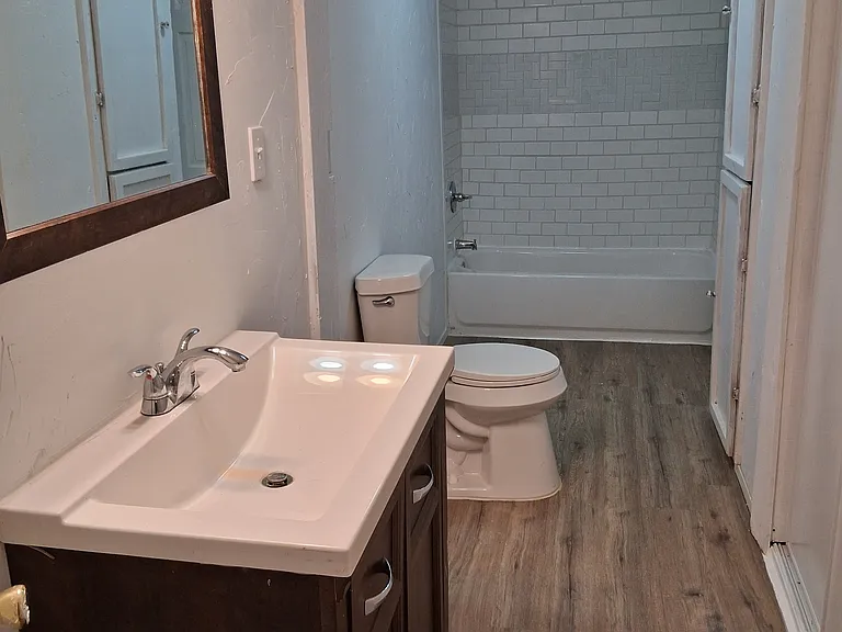 bathroom view from middle bedroom door, the other bathroom door is on the opposite end and opens into hallway/laundry room