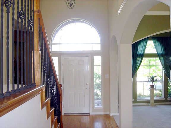 Gorgeous entry opens up to formal LR, Dr, and wood/wrought-iron staircase.