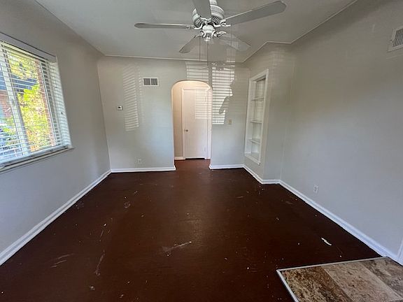 Upstairs den, coped ceiling, archway to bedroom and bath, built-in bookcase. New ceiling fan and portable AC unit. Floor is now painted black, looks great.