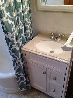 bathroom with updated vanity with multiple drawers.