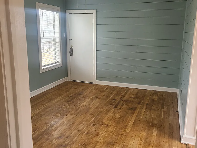Hallway to living room and front door. Kitchen and dining to the right.