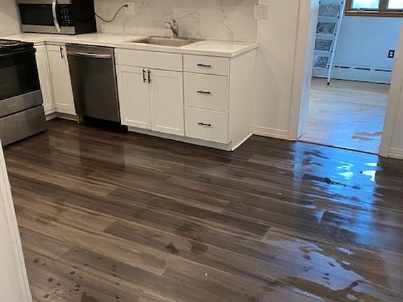 new kitchen cabinets and laminated floor. The door leads to breakfast nook with a side door leading to backyard.