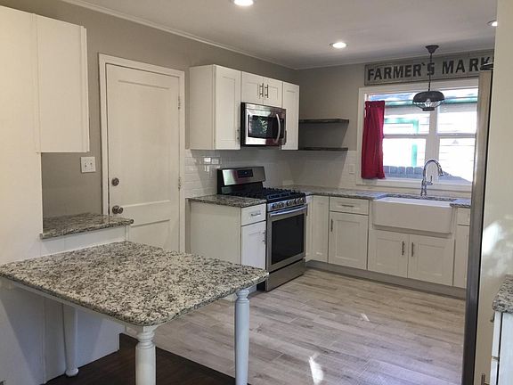 Newer microwave & gas stove, island, and pantry.