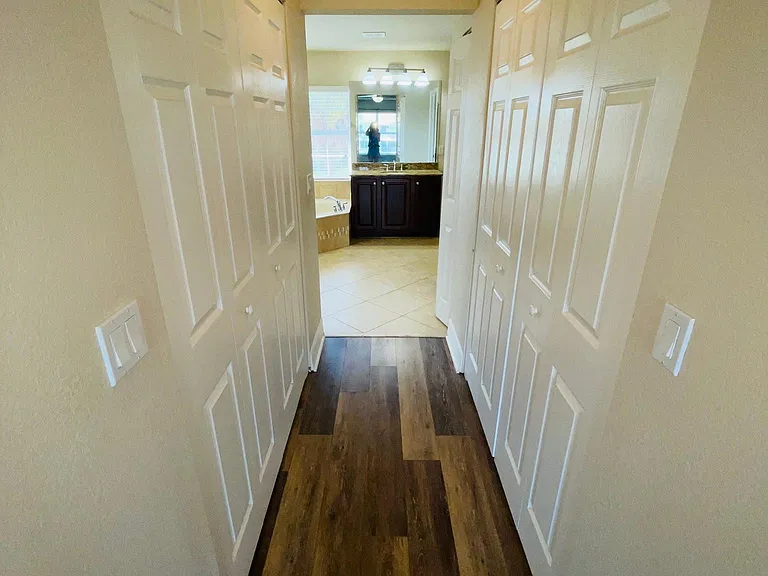 Master BR hallway to bathroom with large wall in closets on each side
