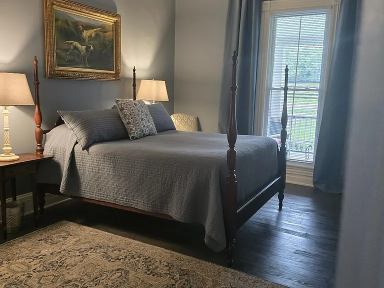 Spring/summer decor - primary bedroom. Queen sized four poster bed. Black out curtains (light, sound). Ceiling fan.