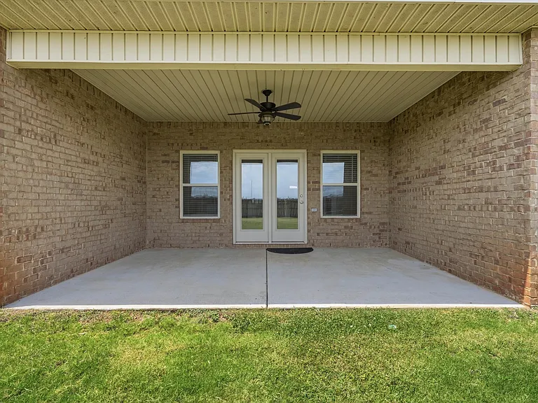 Covered patio with ceiling fan.