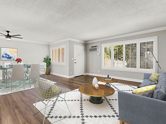 Hardwood floored living room with view of dining area.
