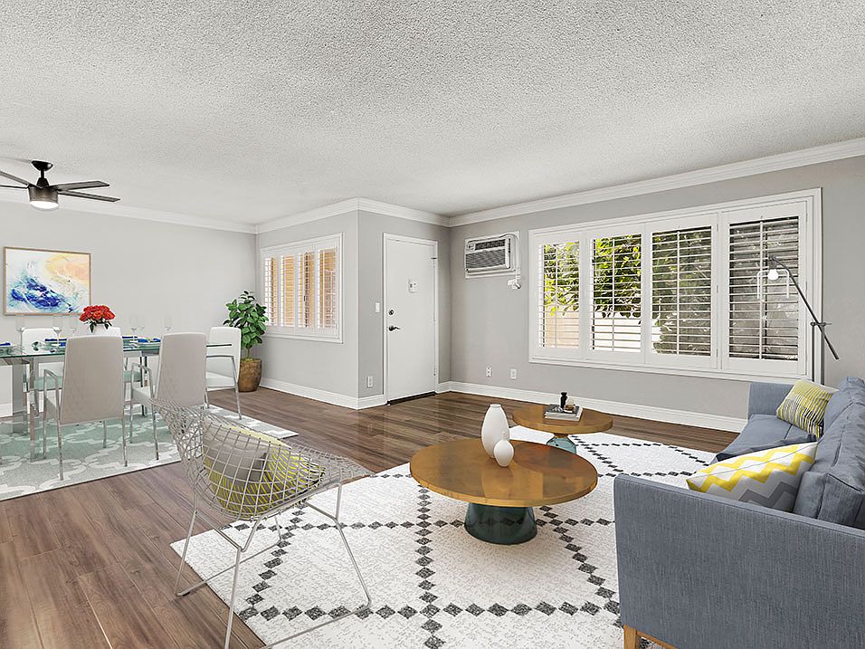 Hardwood floored living room with view of dining area.