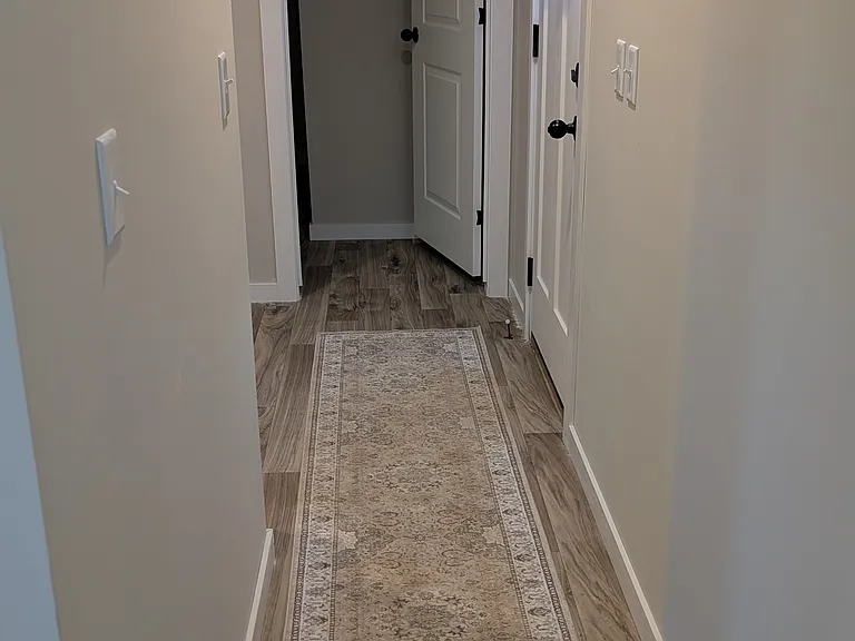Hallway to master bedroom and utility room. Vinyl flooring throughout. Dog friendly.