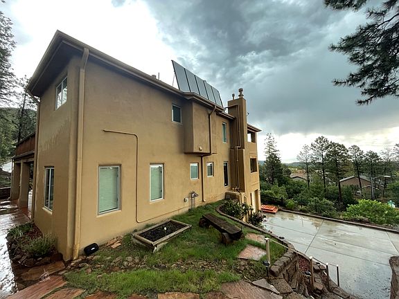 Back of the house and a beautiful bench for sitting.
