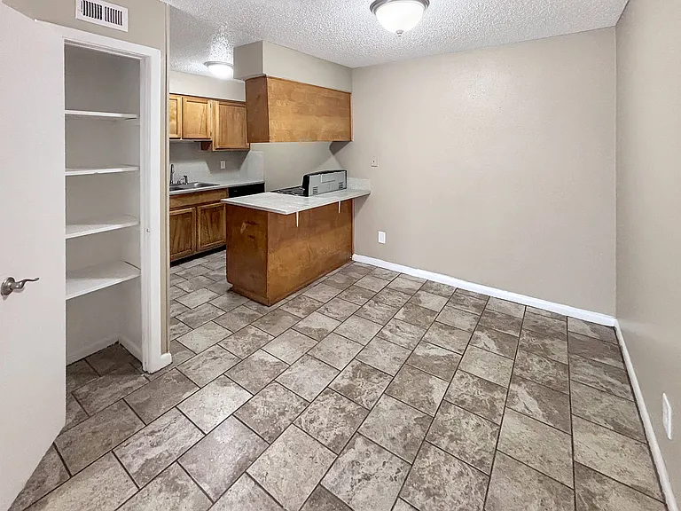 Enjoy a warm kitchen layout with rich wood cabinetry and tiled flooring.