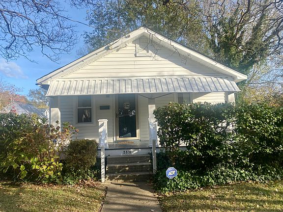 Inviting front porch with awning, private driveway to the left