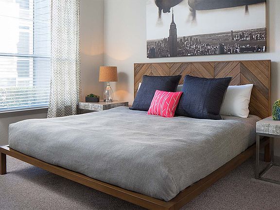 Spacious apartment bedroom with carpeted floors.