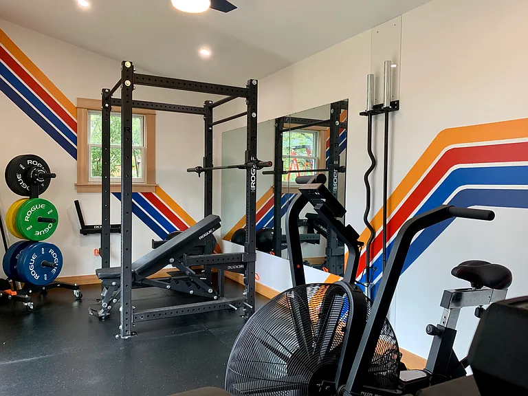 Gym includes a rack for squats, presses, pull-ups, etc.