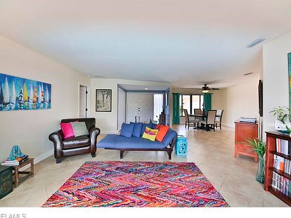 Double door entry foyer to living room and view toward formal dining area.