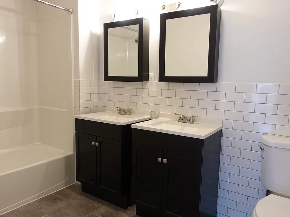 DOUBLE-SINK BATHROOM _ Bright, refreshed bathroom with a spacious double-sink vanity, new flooring and tile, and updated fixtures for a clean, modern feel.