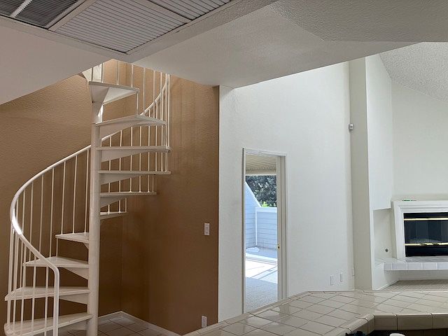 View of winding staircase,master suite, and living room from kitchen