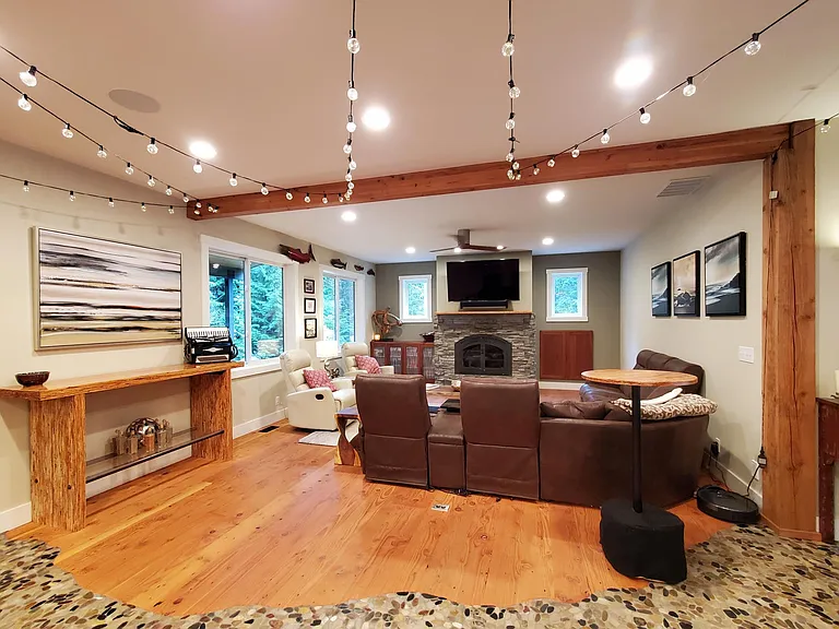 The large family room has comfortable seating and a wood burning fireplace. The cabinet doors to the right of the fireplace access the wood storage box which is loaded from the exterior. Brilliant. Minimal mess but the comfort of wood heat.