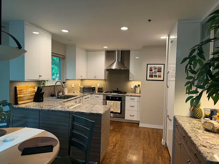 Kitchen and dining space includes gas range, granite countertops, modern appliances, lots of cabinet space for pantry items, and under-cabinet lighting.