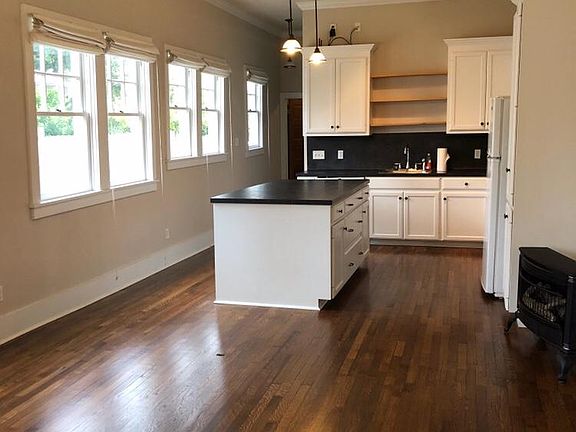 Living room and kitchen from front entrance. Beautifully restored hardwood floors throughout the duplex.
