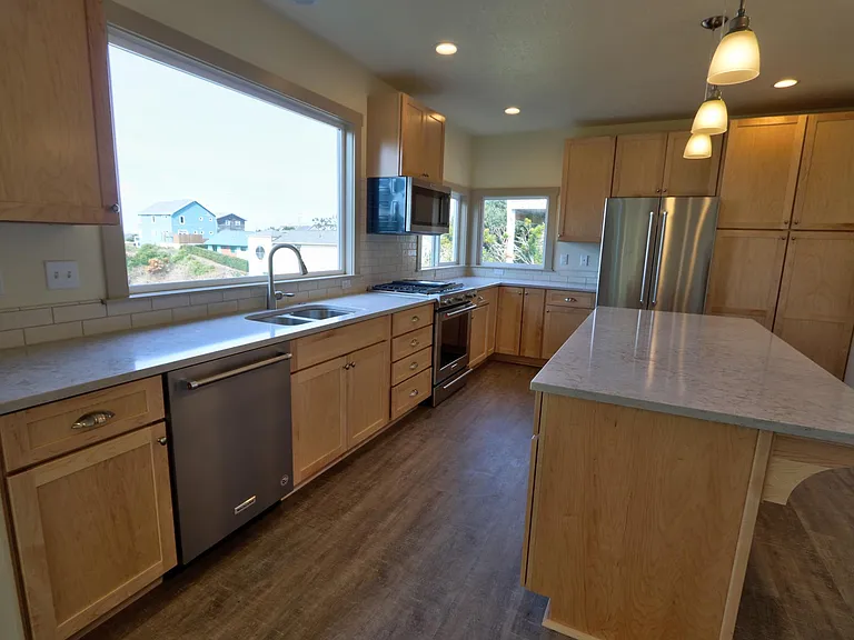 Kitchen with quarts counters and stainless steel appliances. Gas Stove.