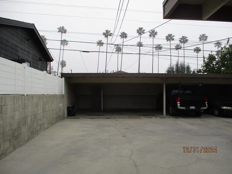 two parking car ports with storage bins behind
