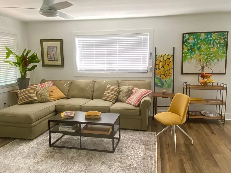 Living room with sectional and Old Florida art.