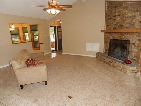 open living room with fireplace, wood storage next to fireplace feeds from the garage