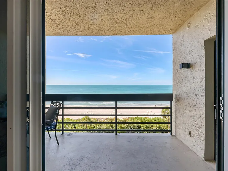A glimpse of the balcony from the living room, access to primary suite door on right.