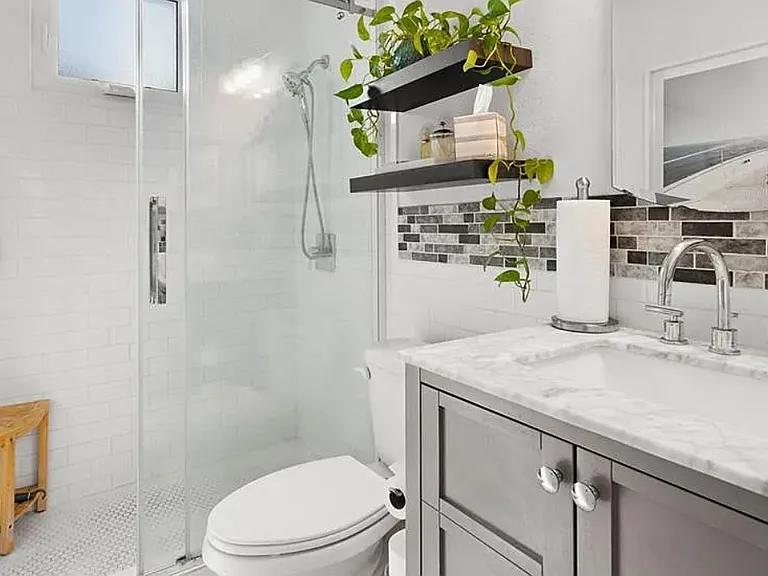Bathroom with vanity and tiled shower with glass door