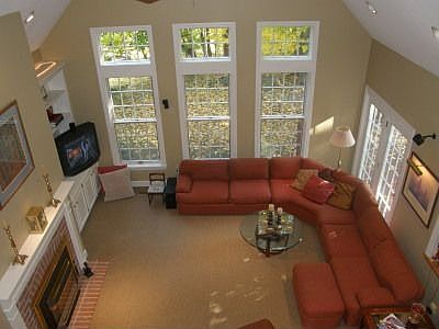 Vaulted great room with wall of windows - custom built in book cases and firep