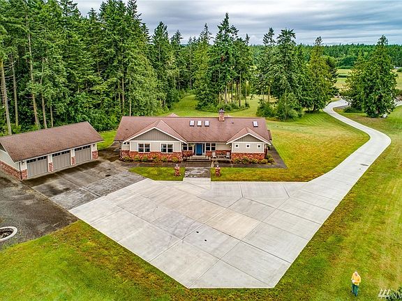 The driveway ascends a gentle slope to the front of the residence and the additional 3-car garage which are sited at the high point of the property.