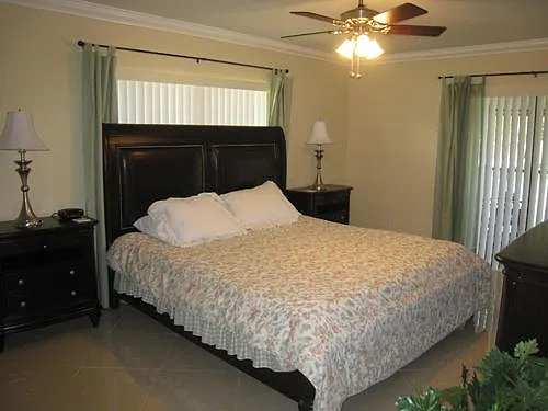 Master room with king bed set with two night stands and two dresser and smart TV. Slider to patio also
