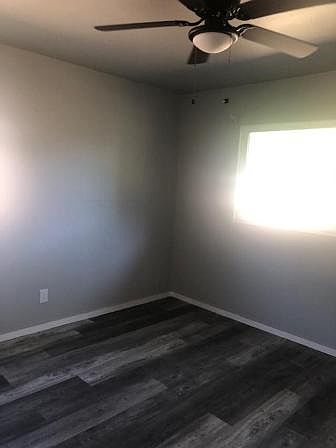 Master bedroom with two windows , same new light fan and laminate floor.