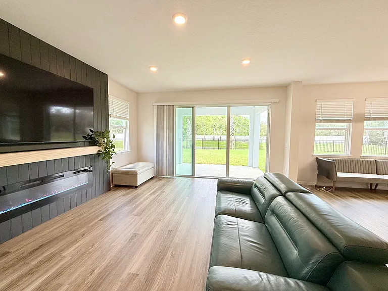 Living Room with entertainment wall, 90" TV, Electric Fireplace and private pond view.