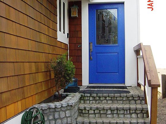 River rock stairs lead to stain glass accented front door
