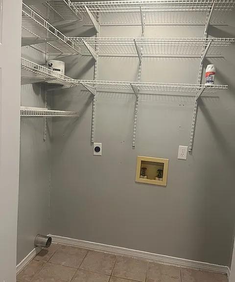 Laundry room off of the kitchen, with washer dryer hookups and ample shelving