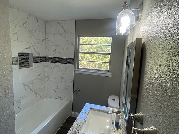 Beautifully bathroom with upgraded lighting, facet, and shower backsplash