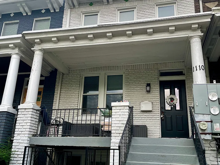 Front of the house, with stairs to unit B on the left leading to a small patio and entrance.