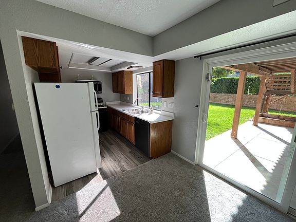 Looking from dining to kitchen with back shared patio and lawn out slider. Laundry also accessed through slider.