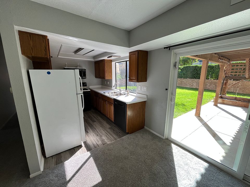Looking from dining to kitchen with back shared patio and lawn out slider. Laundry also accessed through slider.