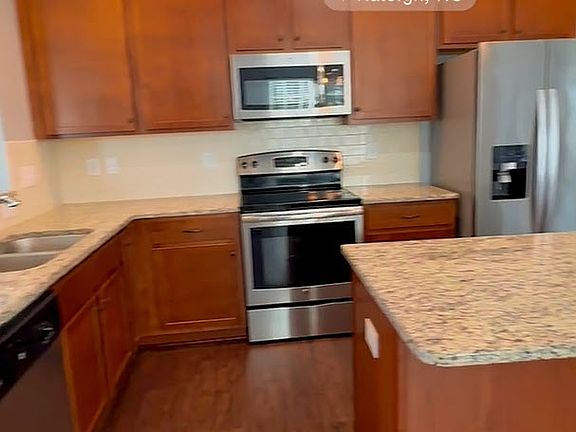 The kitchen features upgraded appliances, including a dishwasher, oven/stove combo, microwave and refrigerator with in-door ice and water.