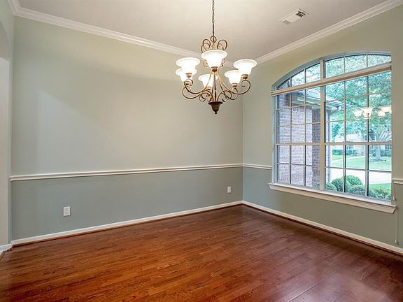A breathtaking formal dining room awaits you and your guests to enjoy a meal together! This room features chair & crown molding, hardwood flooring and a classic wrought iron chandelier!