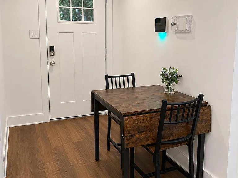 Dedicated dining nook with a two-seat table set beside the entry, offering an easy spot for meals or a work-from-home setup.