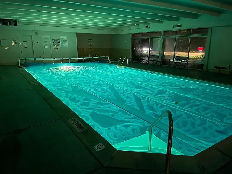 Indoor pool with hot tub in the background