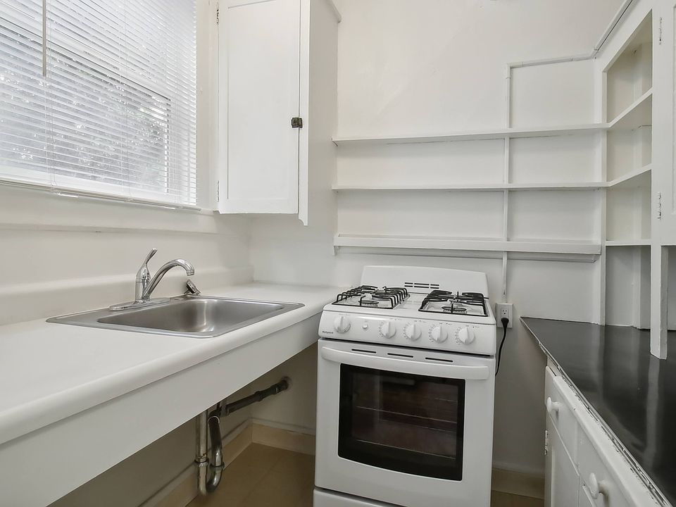 Kitchen with cabinets, stove, and sink
