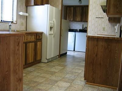 Galley Style Kitchen With Newer Appliances and Vinyl Flooring.Utility Room With Washer,Dryer,& Furna