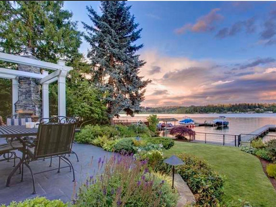 Waterfront patio off kitchen with gated yard and dock with covered boat lift