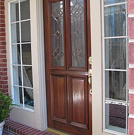 Main door. Architectural wood design surrounded by window lights